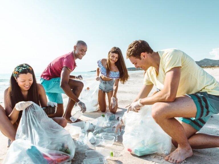 A group of friends cleaning up plastic from a beach