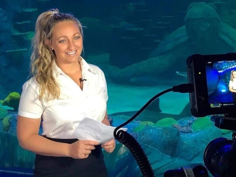 Crystal Lacey Little Fish Tourism and Master Reef Guide being filmed in front of an aquarium